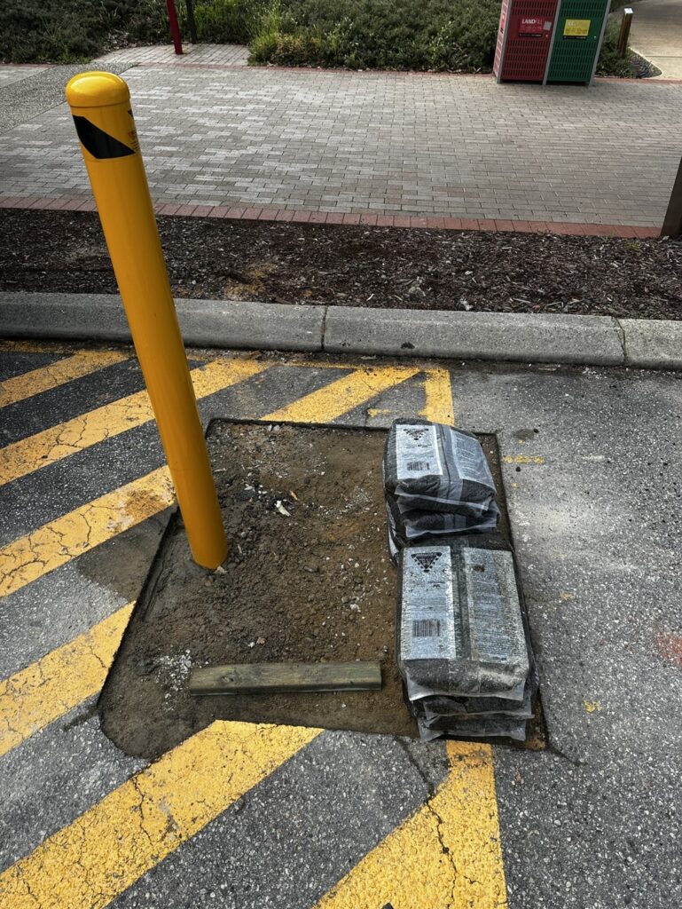 Damaged bollard and broken concrete footing before replacement