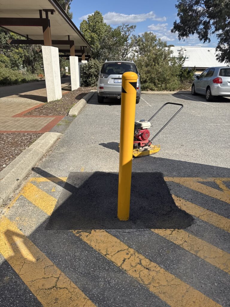 New in-ground bollard installed with reinstated bitumen surface