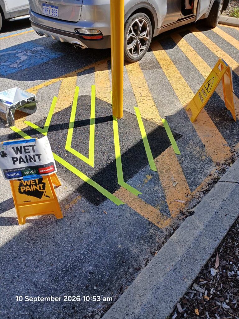 Fresh yellow line marking applied around the new bollard