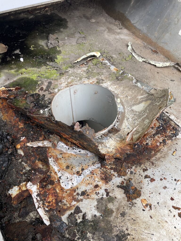Corroded, rusted gutter outlet before replacement