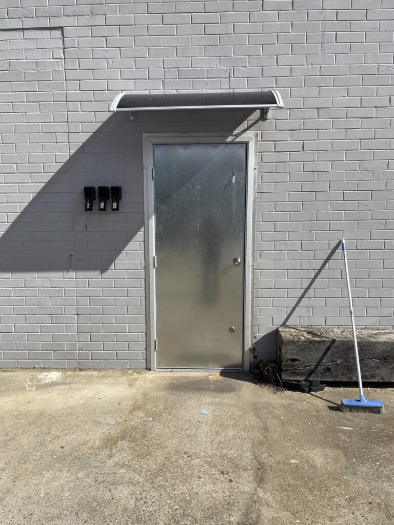 New commercial steel door with a canopy installed above the doorway