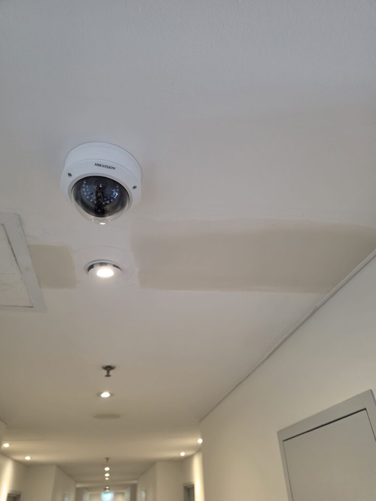 Repaired ceiling area around a smoke detector ready for painting