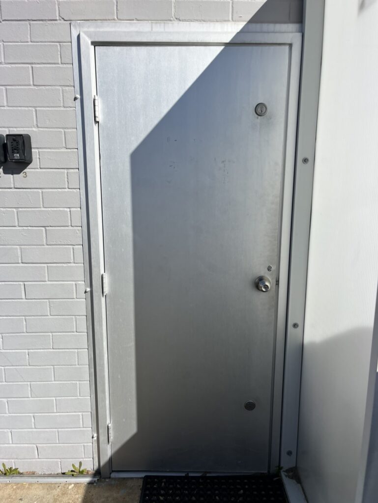 Existing damaged commercial door before replacement
