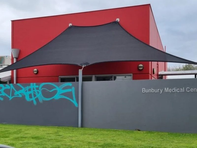 A comparison showing the before and after of a graffiti removal project on a red brick wall.