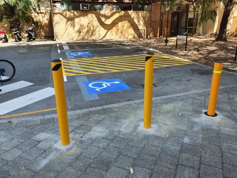 Yellow bollards, wheel stops and line marking at a Perth shopping centre car park