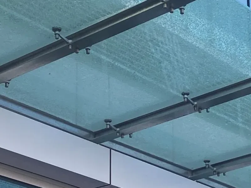 Glass canopy roof edge and steel supports at a shopfront