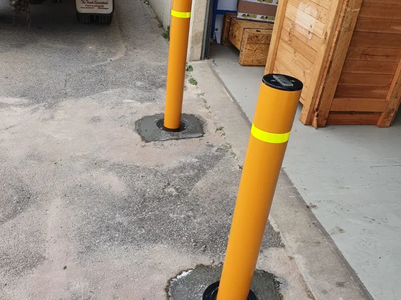 In-ground bollard installed in a concrete base at a commercial loading area