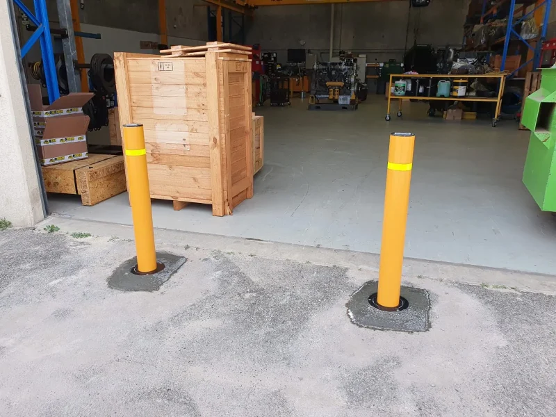 In-ground yellow bollards installed at a commercial loading area