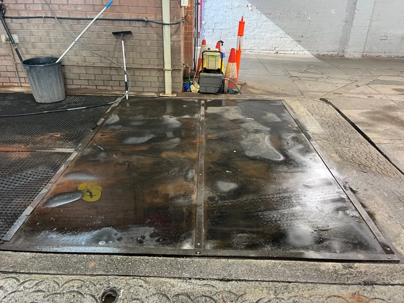 Metal floor matting in a vehicle bay, wet and worn