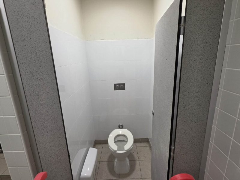 Completed washroom cubicle with repaired and painted walls